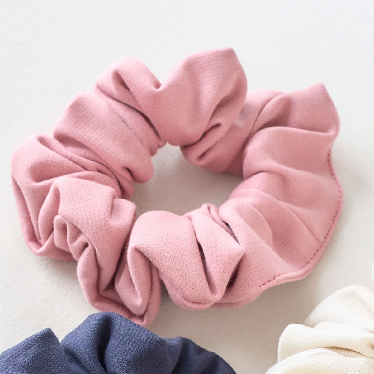 低身長ワンピースと同じ生地を使用したピンク色のシュシュ