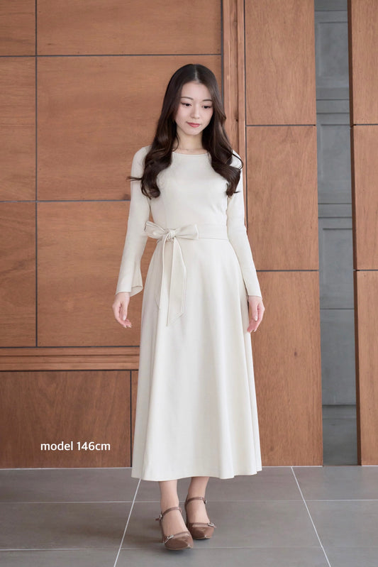 アイボリー色のリボン付き低身長ワンピースを着用した正面姿