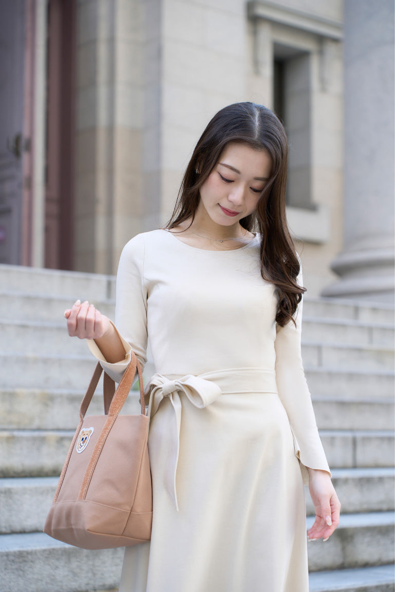 アイボリー色のリボン付き低身長ワンピースを着用したアップ姿