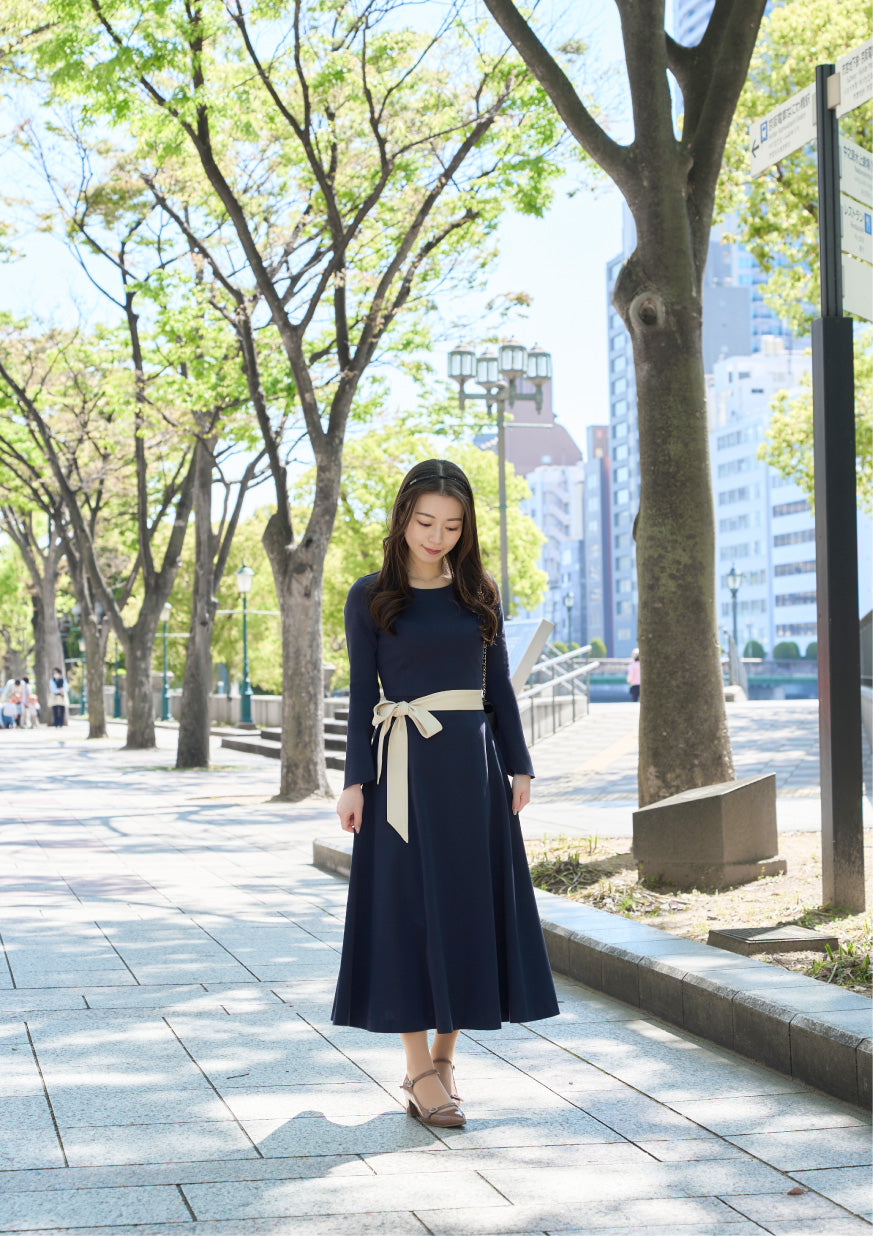 ネイビー色のリボン付き低身長ワンピースを着用したロケでの正面姿