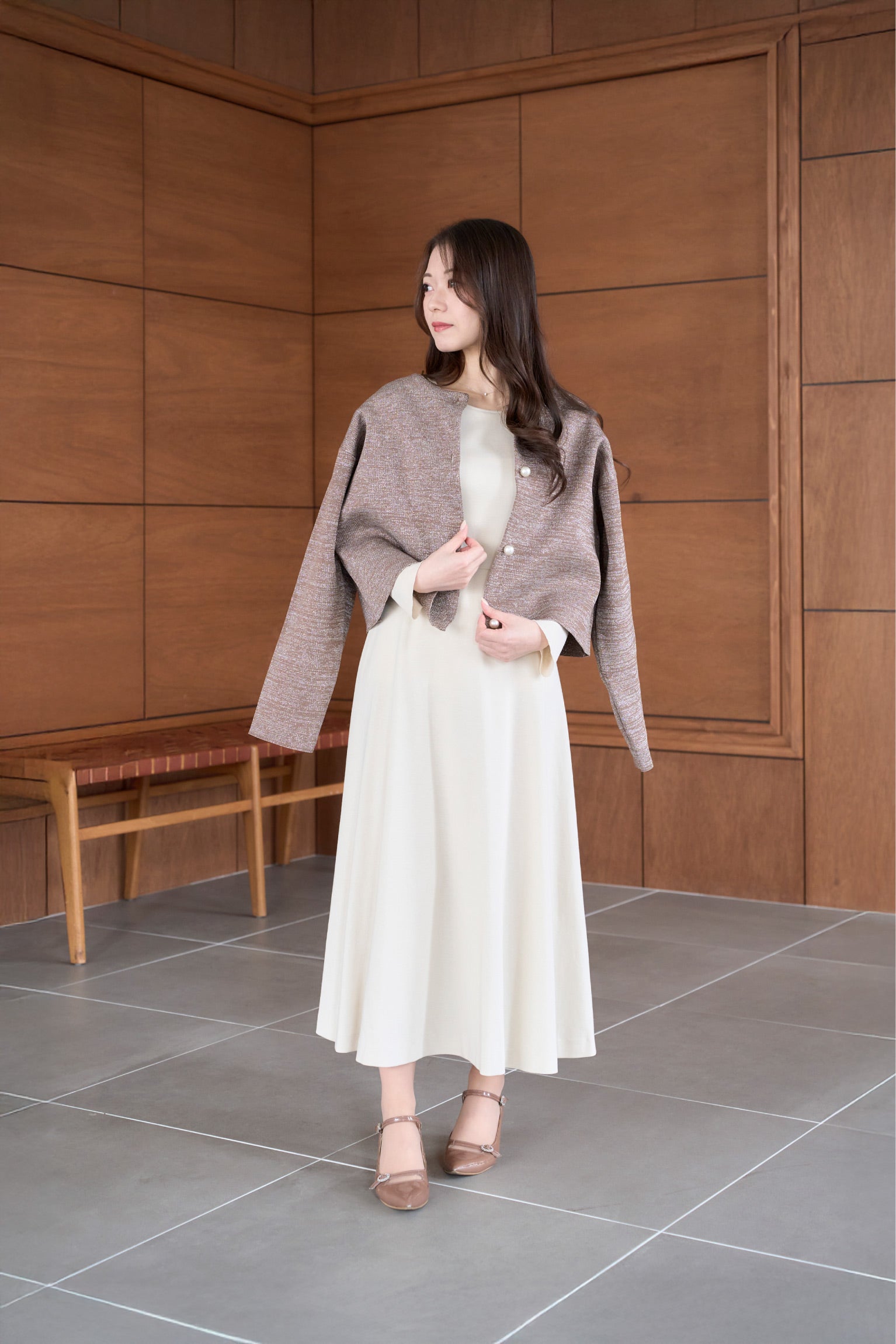 ベージュ色低身長ワンピースに秋ジャケットを着用した正面姿