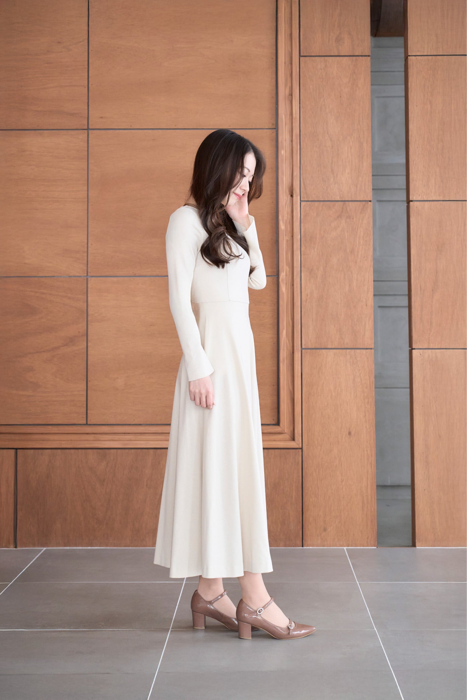 ベージュ色低身長ワンピースを着用した横姿