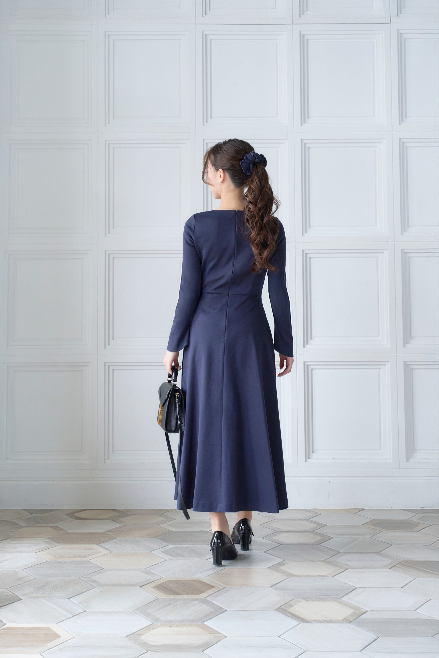 ネイビー色低身長ワンピースを着用した後ろ姿