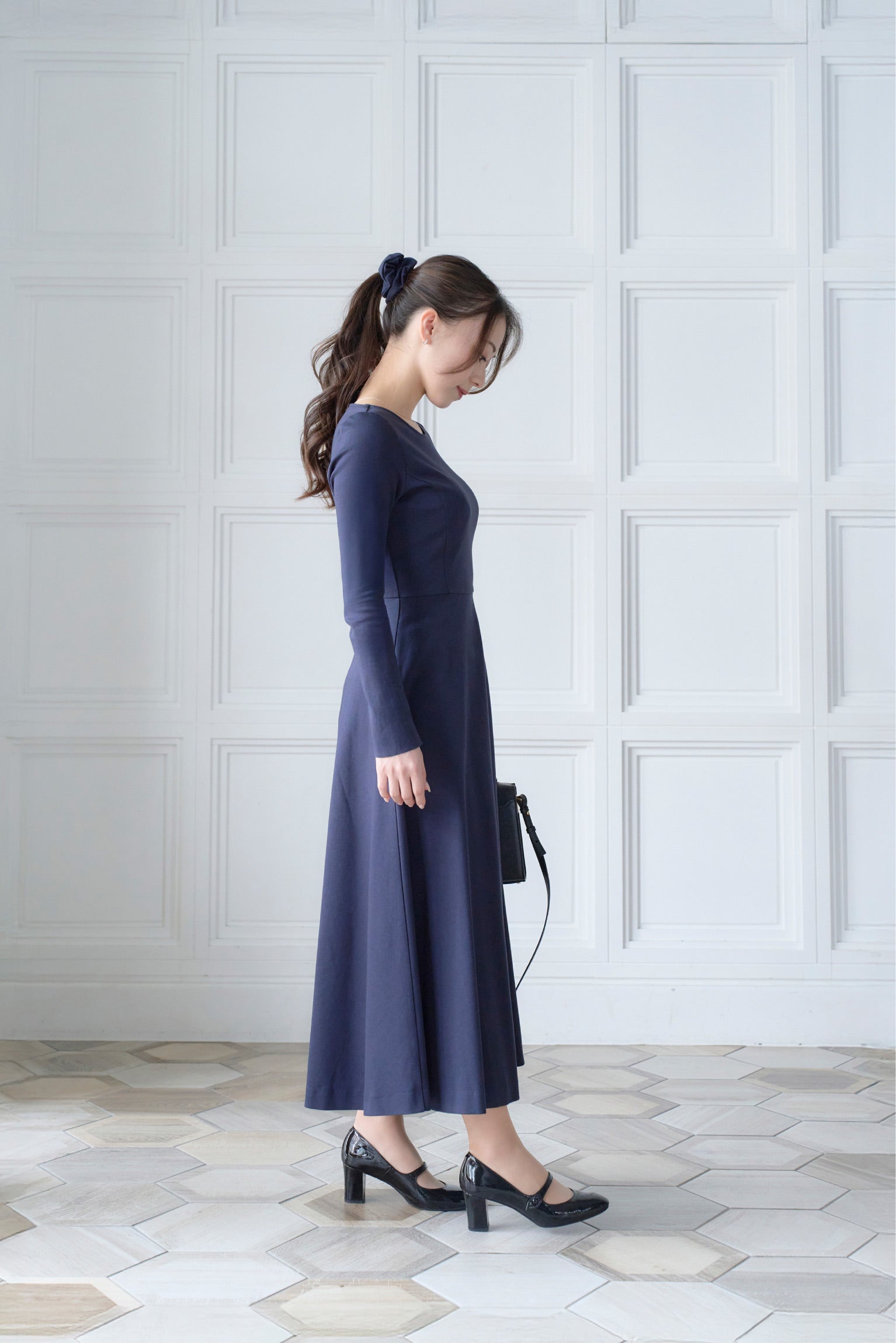 ネイビー色低身長ワンピースを着用した横姿