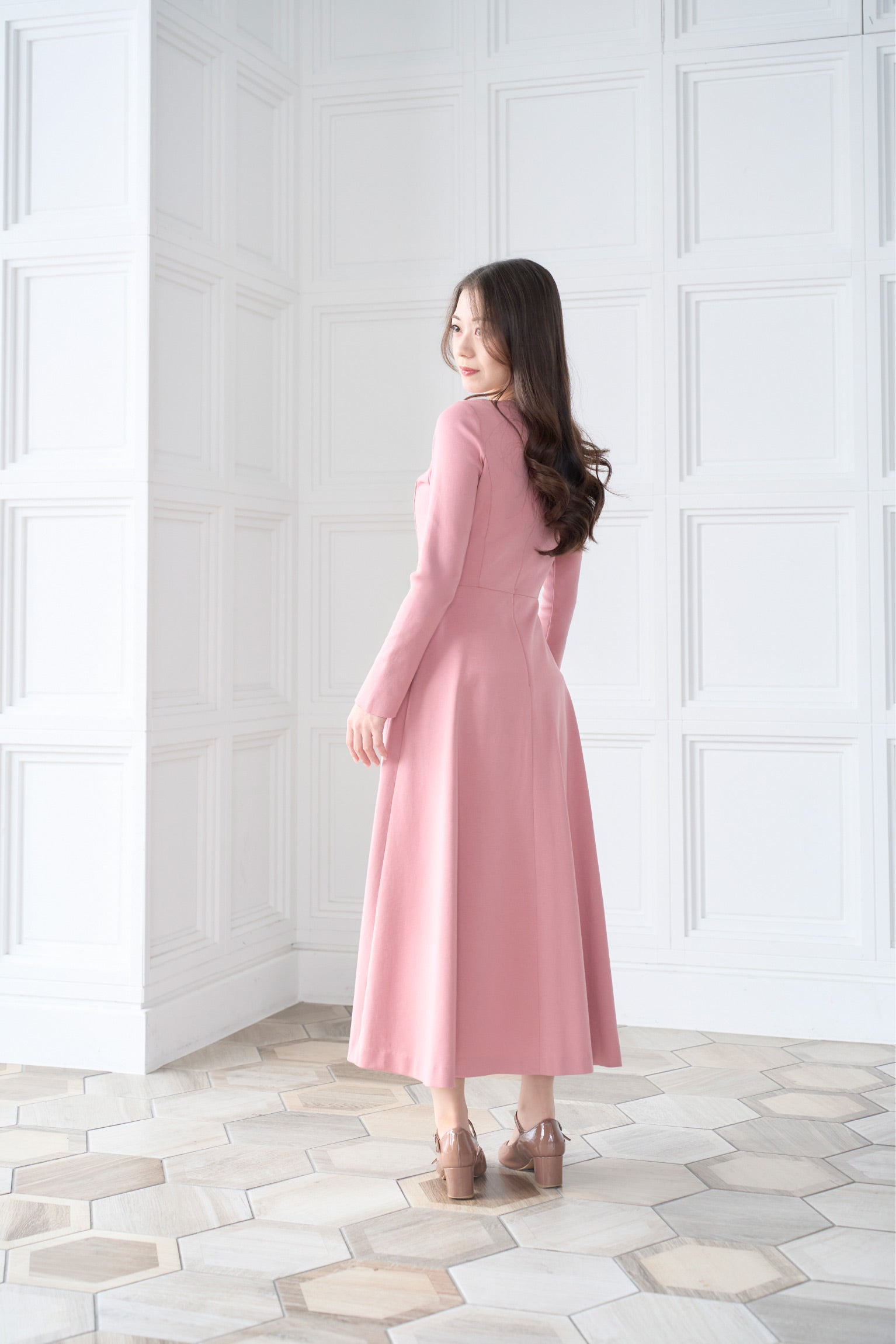 ピンク色低身長ワンピースを着用した後ろ姿