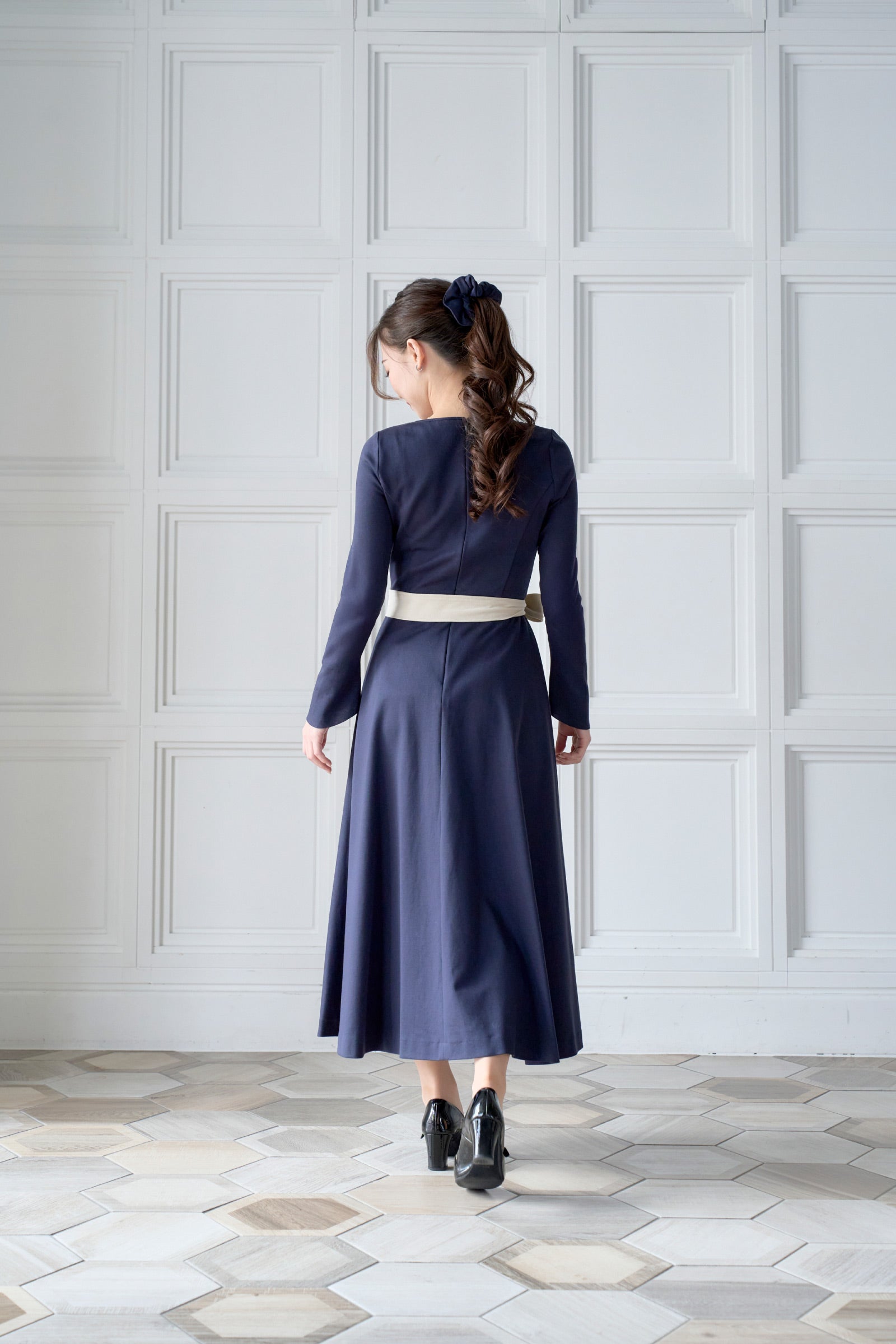 リボン付きのネイビー色低身長ワンピースを着用した後ろ姿