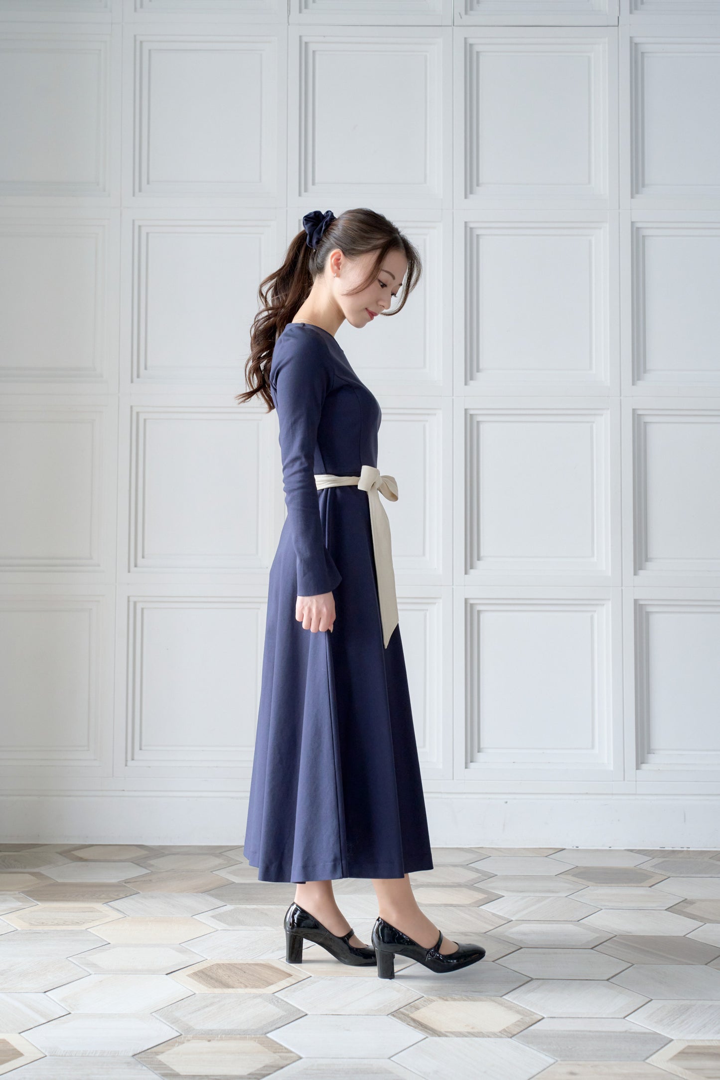 リボン付きのネイビー色低身長ワンピースを着用した横姿