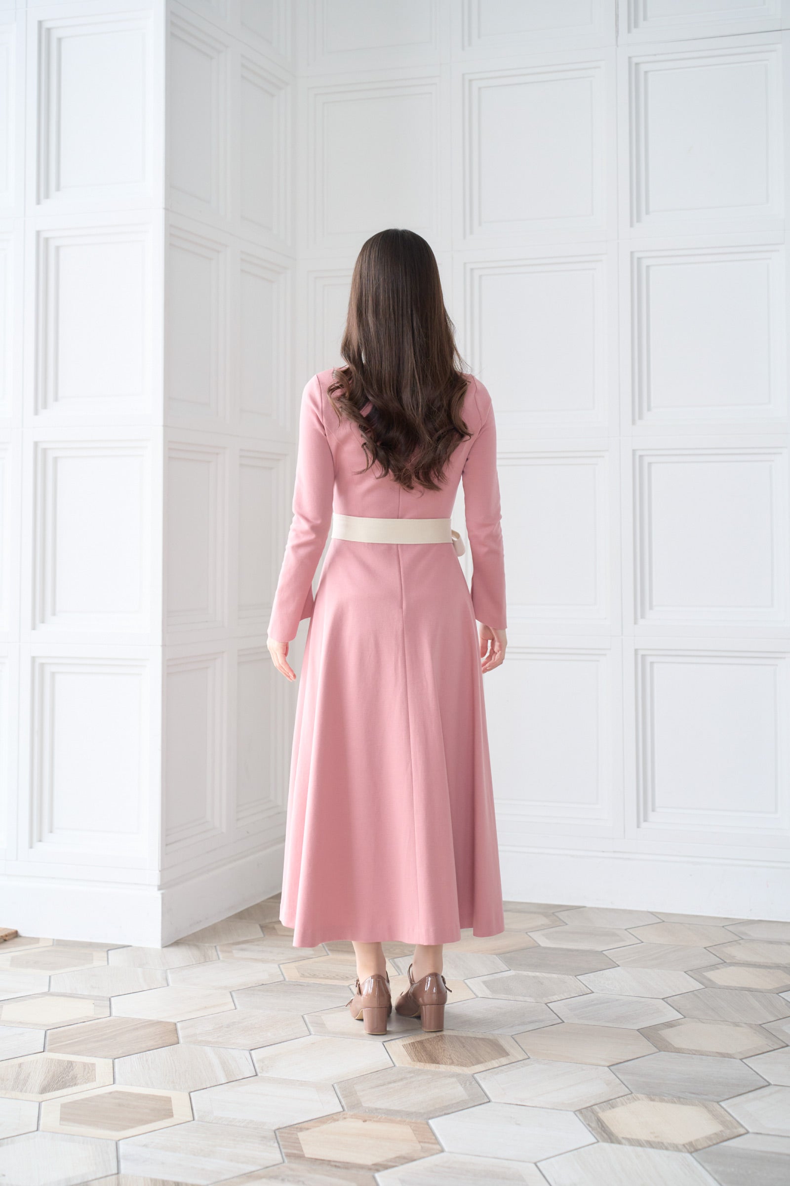 リボン付きのピンク色低身長ワンピースを着用した後ろ姿