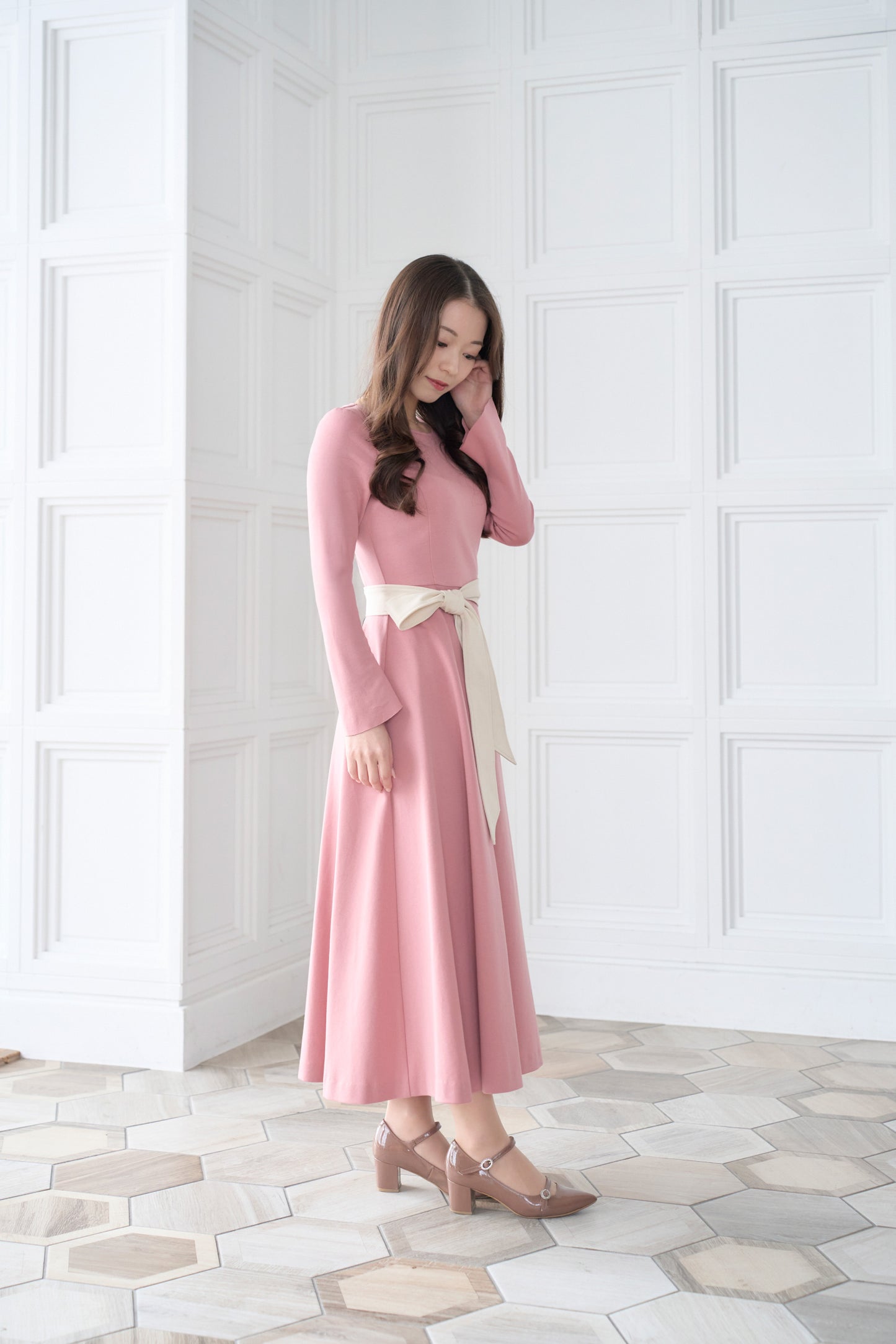 リボン付きのピンク色低身長ワンピースを着用した横姿