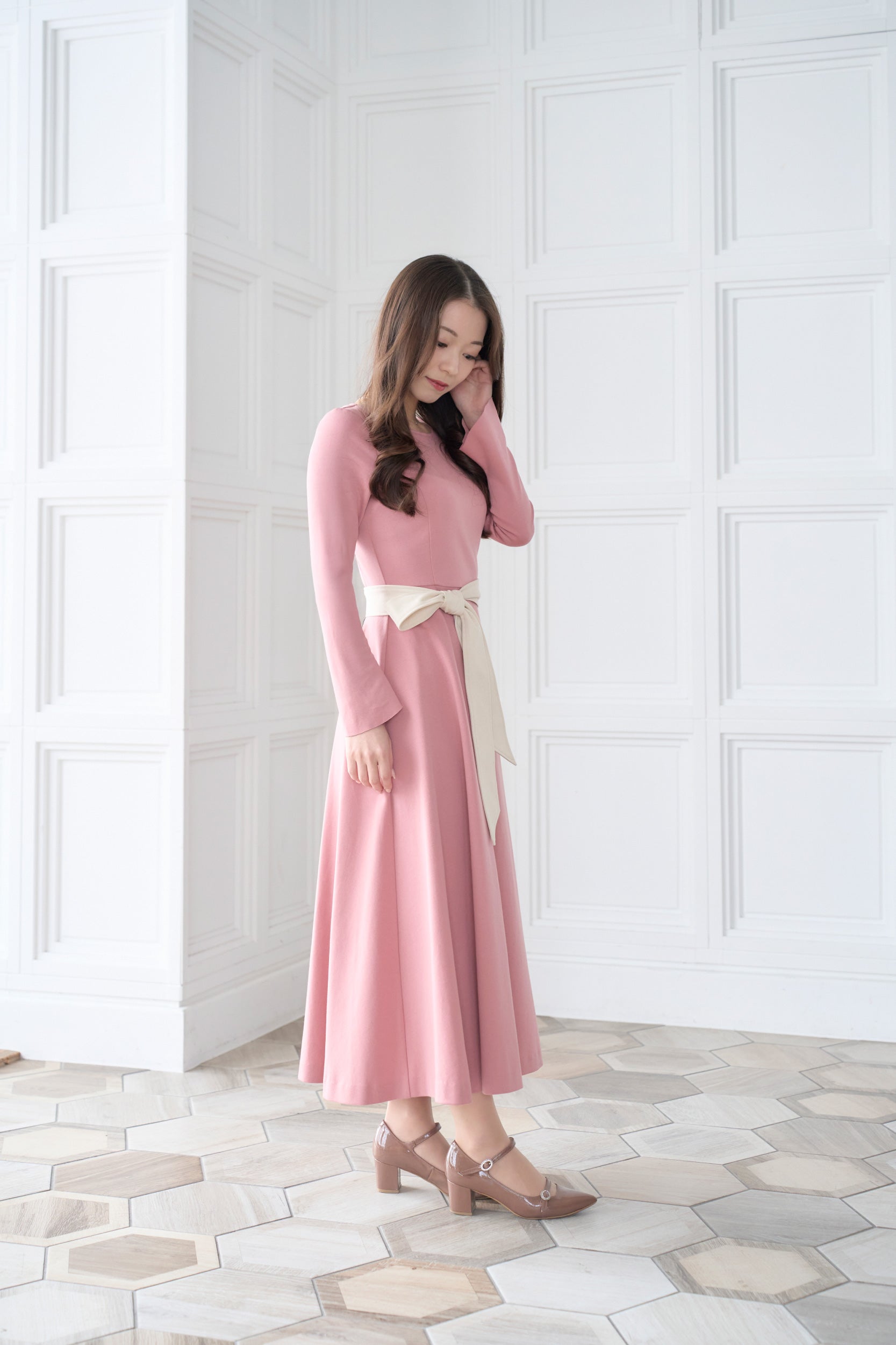 リボン付きのピンク色低身長ワンピースを着用した横姿